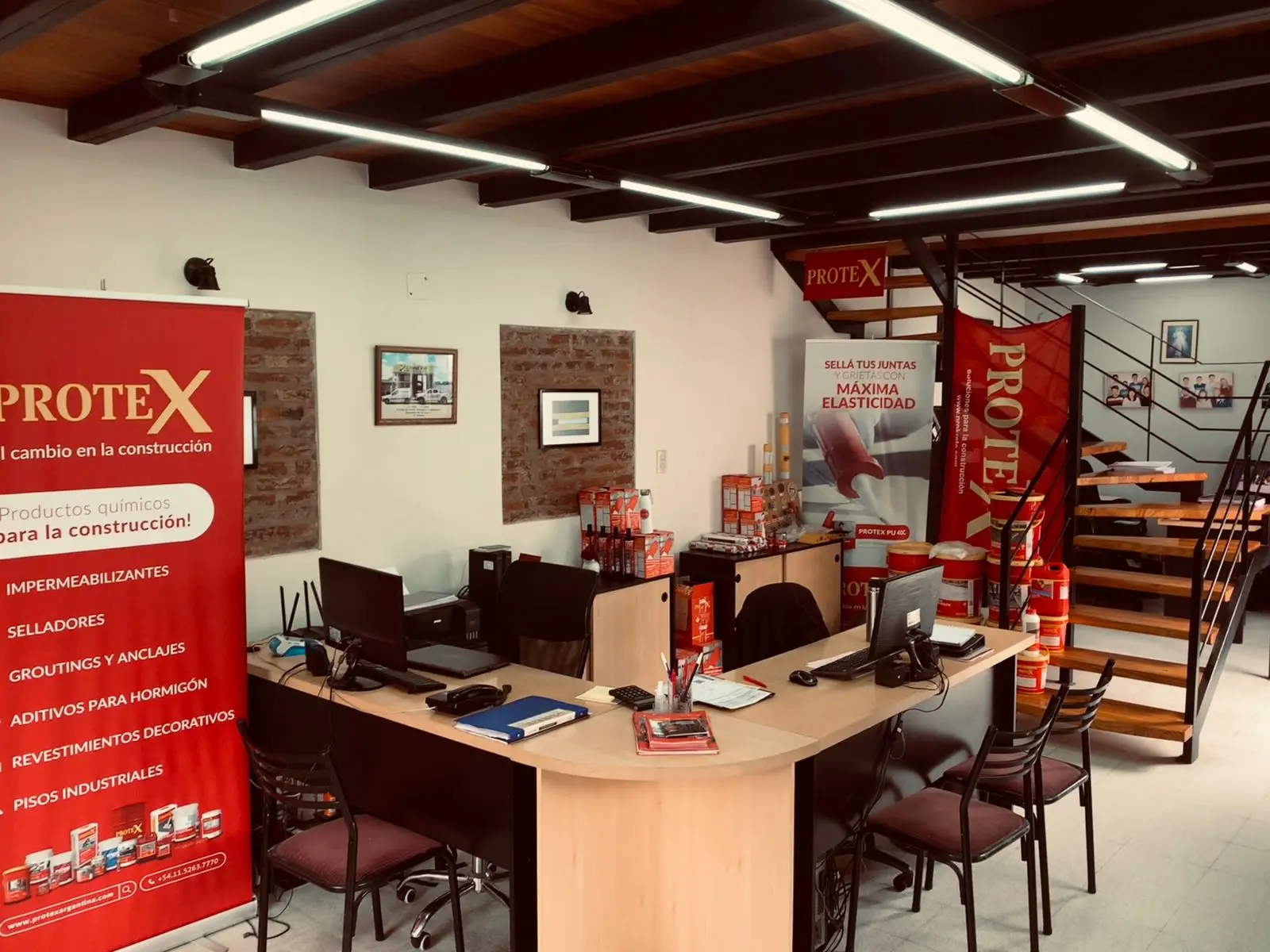Depósito interno con bolsas de material apiladas y rotuladas a mano según su medida, junto a un banner de la línea de impermeabilizantes Protex.
